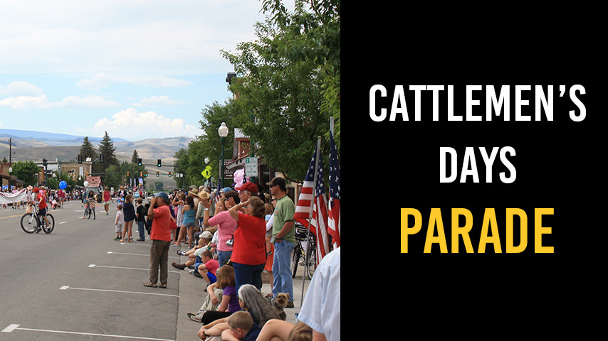 A crowd watches the Cattlemen's Days Parade from the sidewalk.