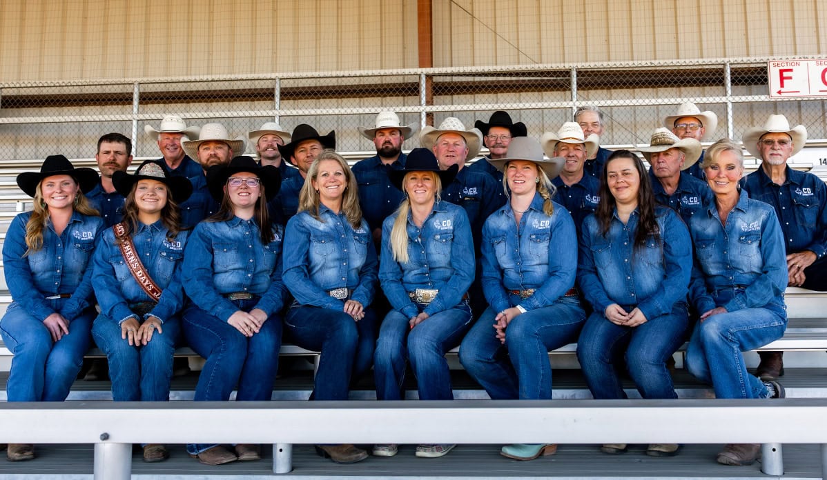 2026 Cattlemen's Days Committee in denim and cowboy hats in the fairground grandstands.